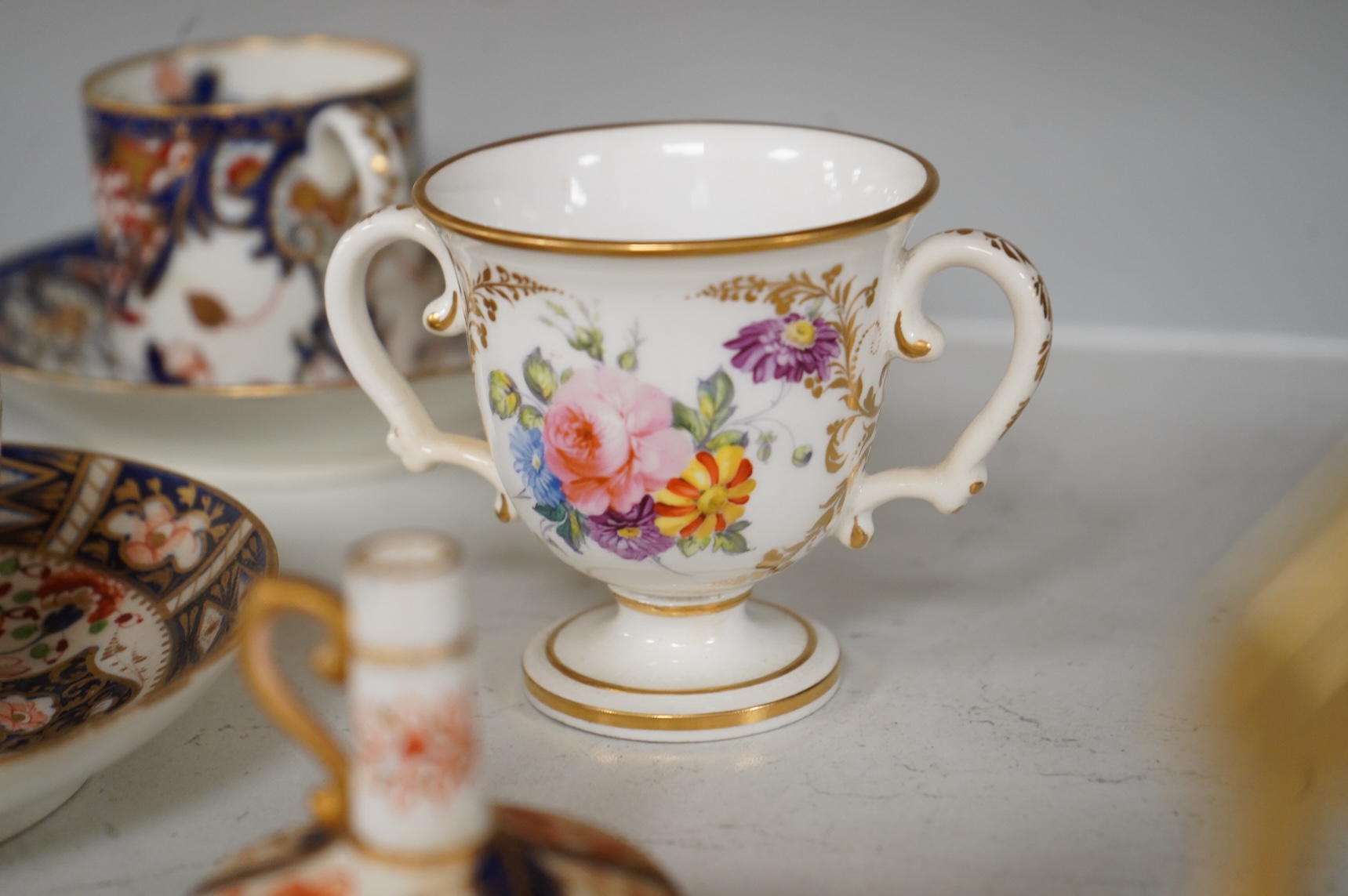 A collection of late 18th/19th century English and French porcelain coffee cans, tea cups and vases, some in Imari pattern